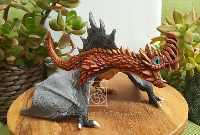 Sculpture of a spiky copper wyvern.