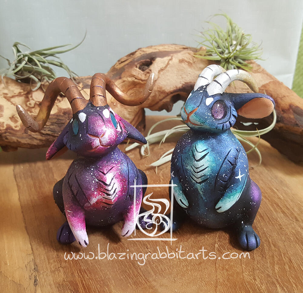 Sculptures of a pink and blue galaxy Jackalope.